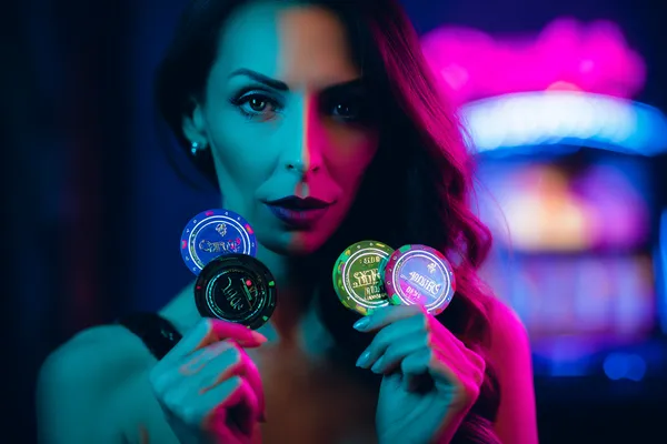 A woman smiling by bright slot machines showing lucky symbols, showcasing the exciting slot offerings at MINIMEO.